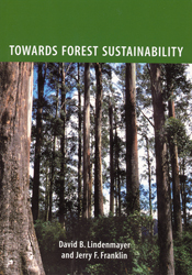 The cover image of Towards Forest Sustainability, featuring an upward view of tall brown tree trunks and their foliage.