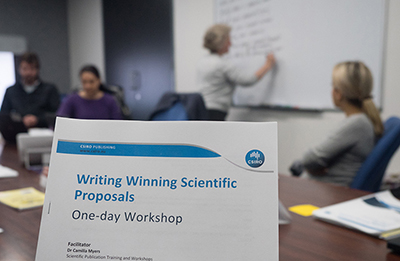 photo of documents with text which reads Writing Winning Scientific Proposals