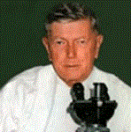 Photograph of Dr MacFarlane Burnet behind a microscope.