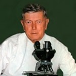 Photograph of Dr MacFarlane Burnet behind a microscope.